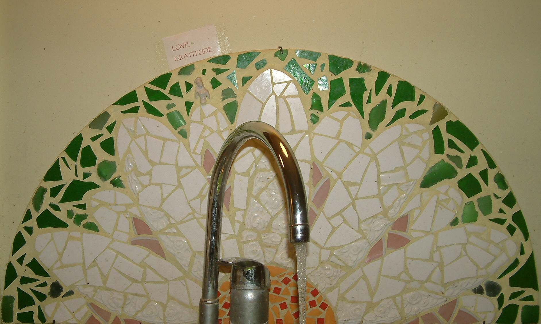 Lotte Rosenkilde. Mosaik med blomst ved køkkenvask.