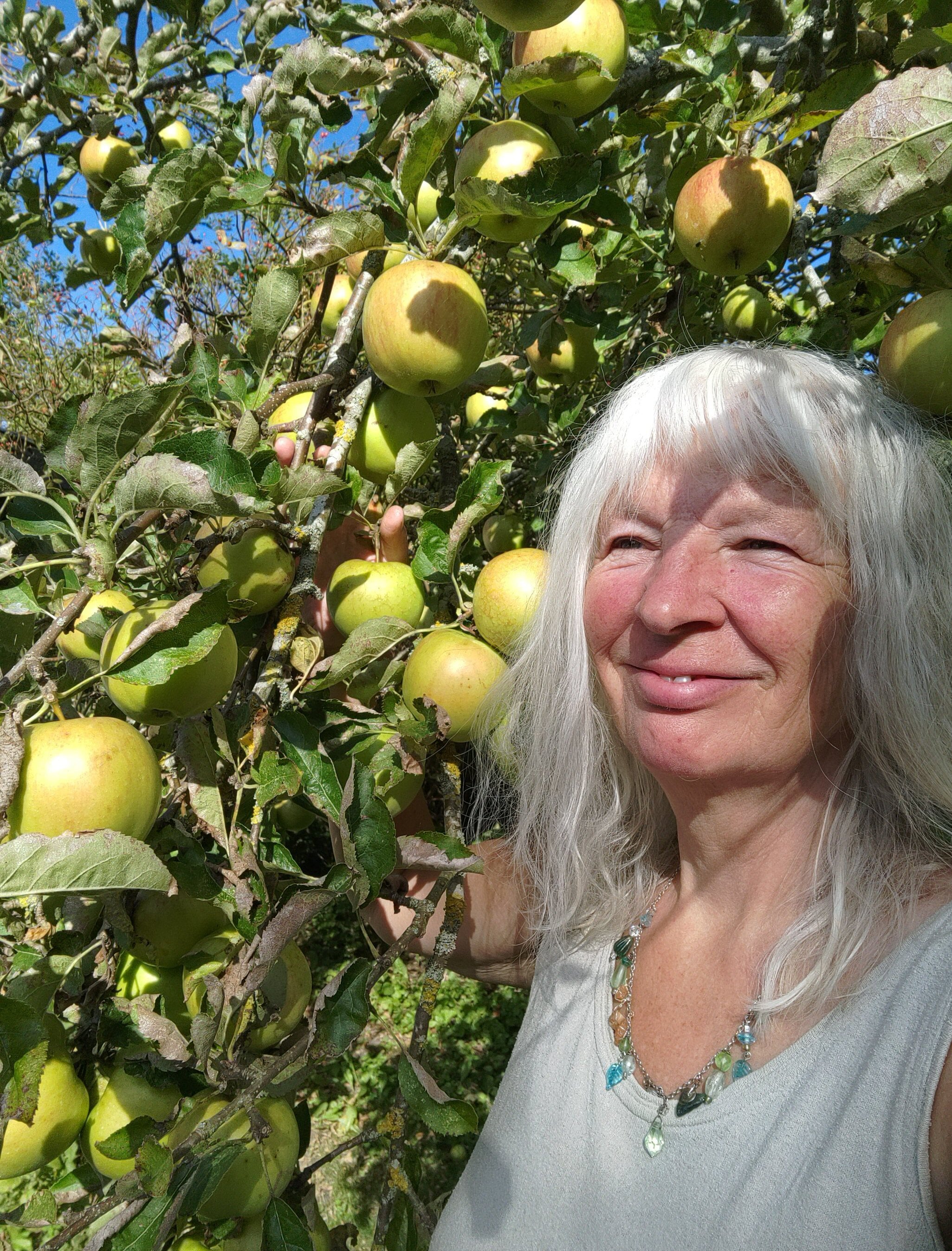 Selvportræt Lotte Rosenkilde ved æbletræ.