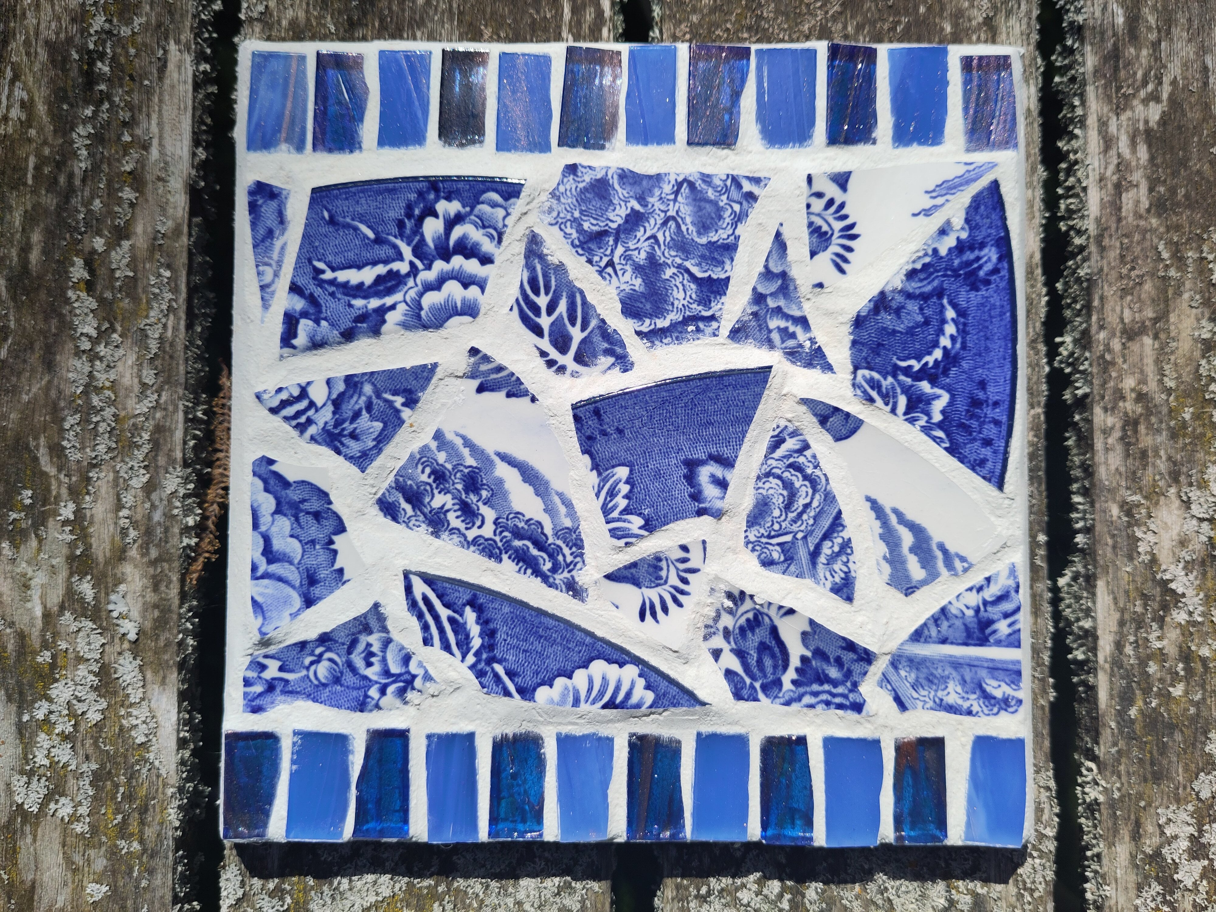 Mosaikbordskåner med blåmønstrede skår og hvid fuge. Lotte Rosenkilde.