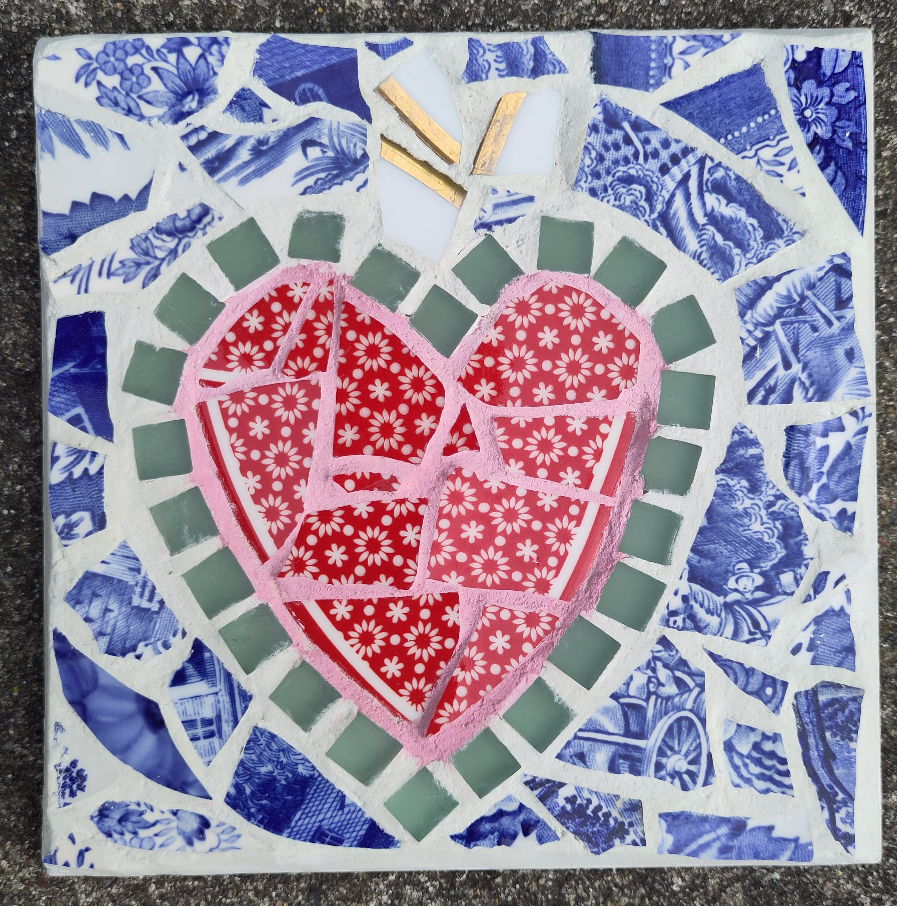 Mosaikbordskåner med rødt, blomstret hjerte mønstrede blå skår og hvid fuge. Lotte Rosenkilde.